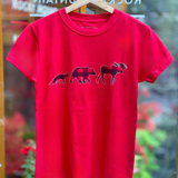 Red t-shirt with moose, bear and fox graphic on a hanger in front of a store window.