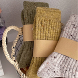 Basket with pairs of socks in various colors on a white surface.