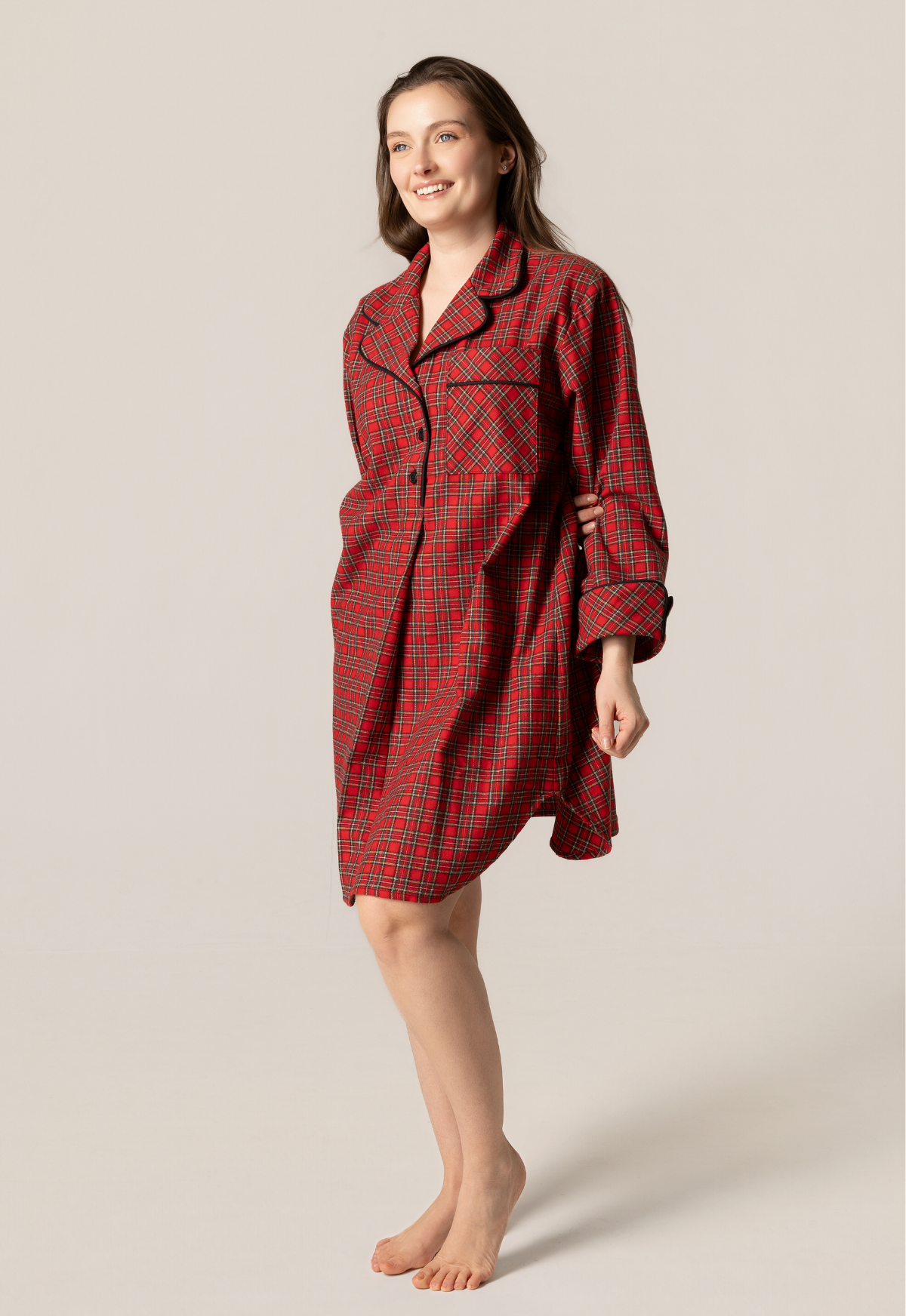 Woman wearing a red plaid nightshirt against a beige background