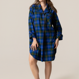 Woman wearing a blue plaid nightshirt against a plain background