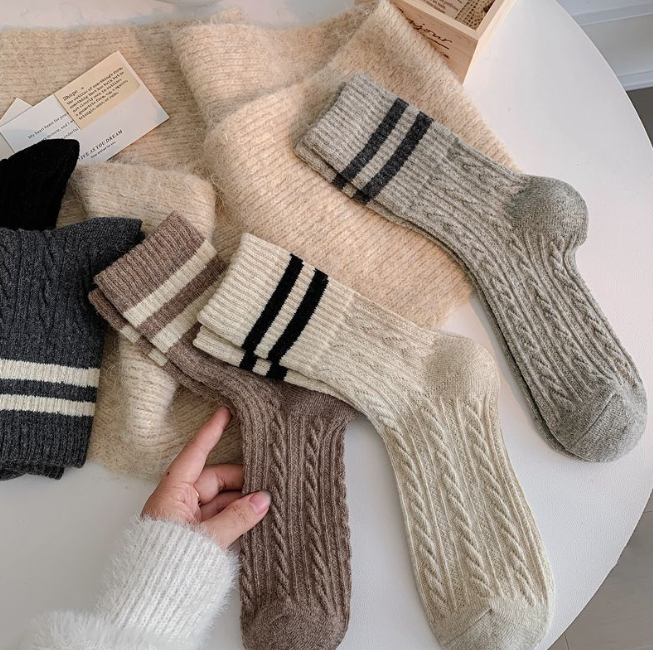 Collection of woolsocks in various colors on a white surface.