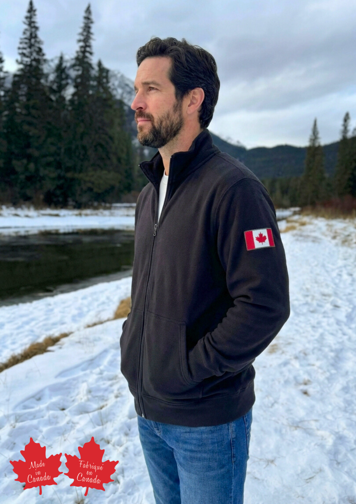 Man wearing a dark jacket with a Canadian flag patch in a snowy landscape.