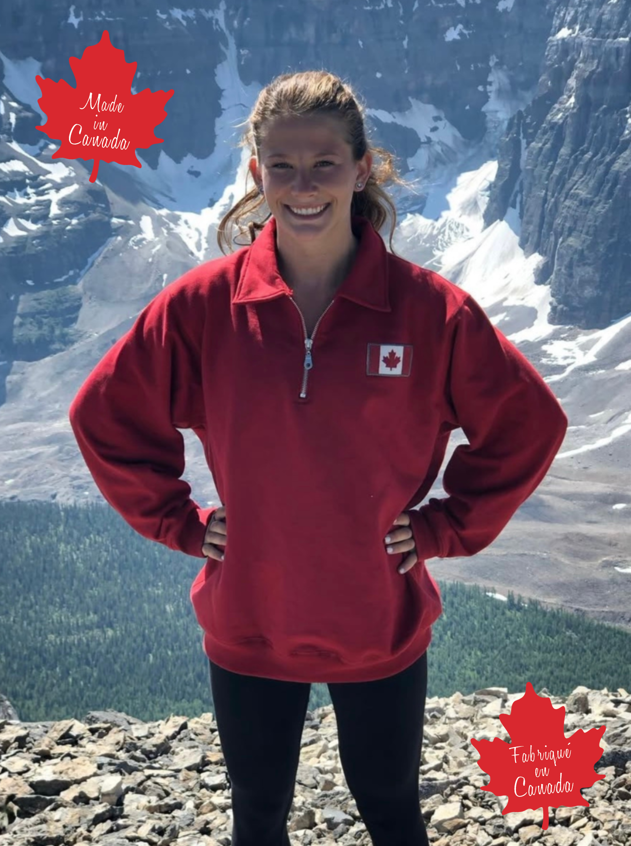 Person wearing a red pullover with a Canadian flag, standing in front of mountainous landscape.
