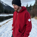 Full Zip red Hoodie with white canada maple leaf logo on left arm.