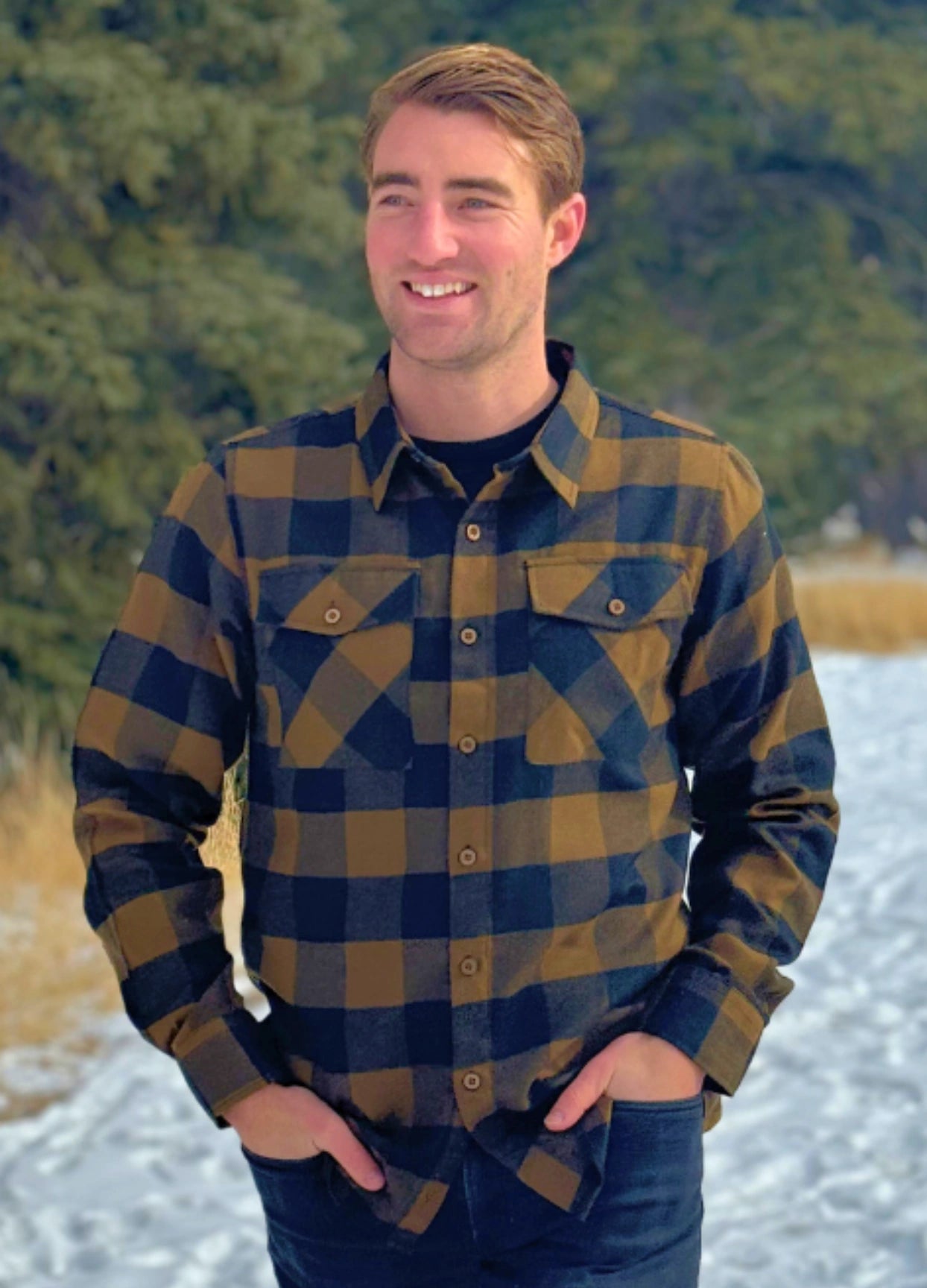 Black and Brown Buffalo Check Flannel Shirt outside in the snow. The shoulder is cut wider, the hip is cut narrower.. the sleeves will always be longer! 60% Cotton / 40% Polyester, brushed slightly on both sides for that "Flannel" feel. Two flap breast pockets. Two button cuff.
Shirttail hemline. 
