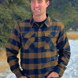 Black and Brown Buffalo Check Flannel Shirt outside in the snow. The shoulder is cut wider, the hip is cut narrower.. the sleeves will always be longer! 60% Cotton / 40% Polyester, brushed slightly on both sides for that "Flannel" feel. Two flap breast pockets. Two button cuff.
Shirttail hemline. 
