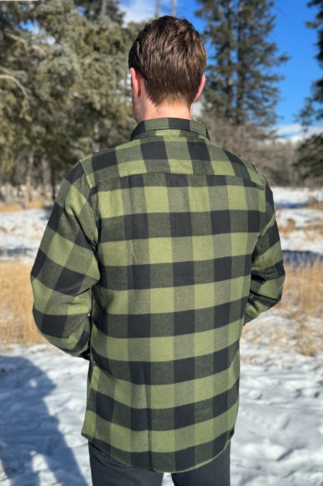 Back view of a man wearing a black and olive buffalo check flannel shirt with two flap breast pockets and a two button cuff.