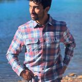 Man wearing a plaid flannel shirt by a river in Banff National Park