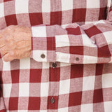 Close up of a burgundy and white buffalo check flannel shirt. Highlighting the button on the cuff.