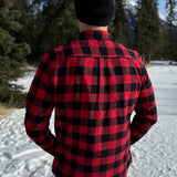 Back view of a man wearing a classic Canadian red and black buffalo check button-down shirt with a single pocket on the chest.