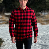 A man wearing a classic Canadian red and black buffalo check button-down shirt with a single pocket on the chest.