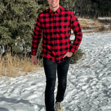 A man wearing a classic Canadian red and black buffalo check button-down shirt with a single pocket on the chest.