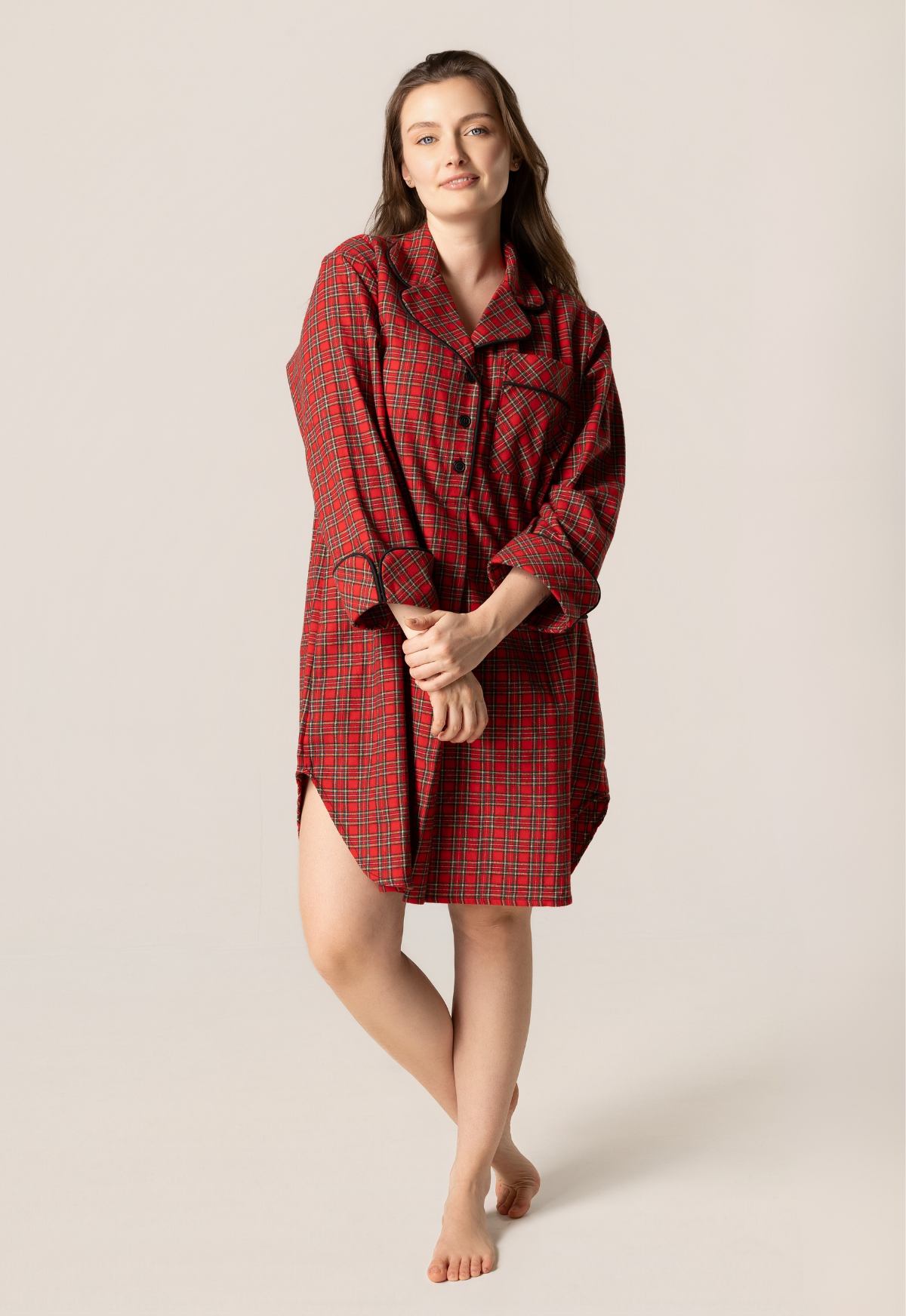 Woman wearing a red plaid shirt dress against a beige background