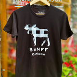 Black t-shirt with moose graphic and 'Banff Canada' text on a hanger against a blurred background.