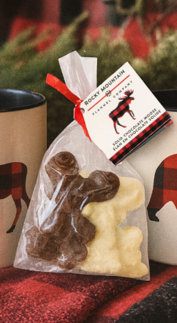 Bag of Rocky Mountain Chocolates with a tag on a red and black checkered surface.