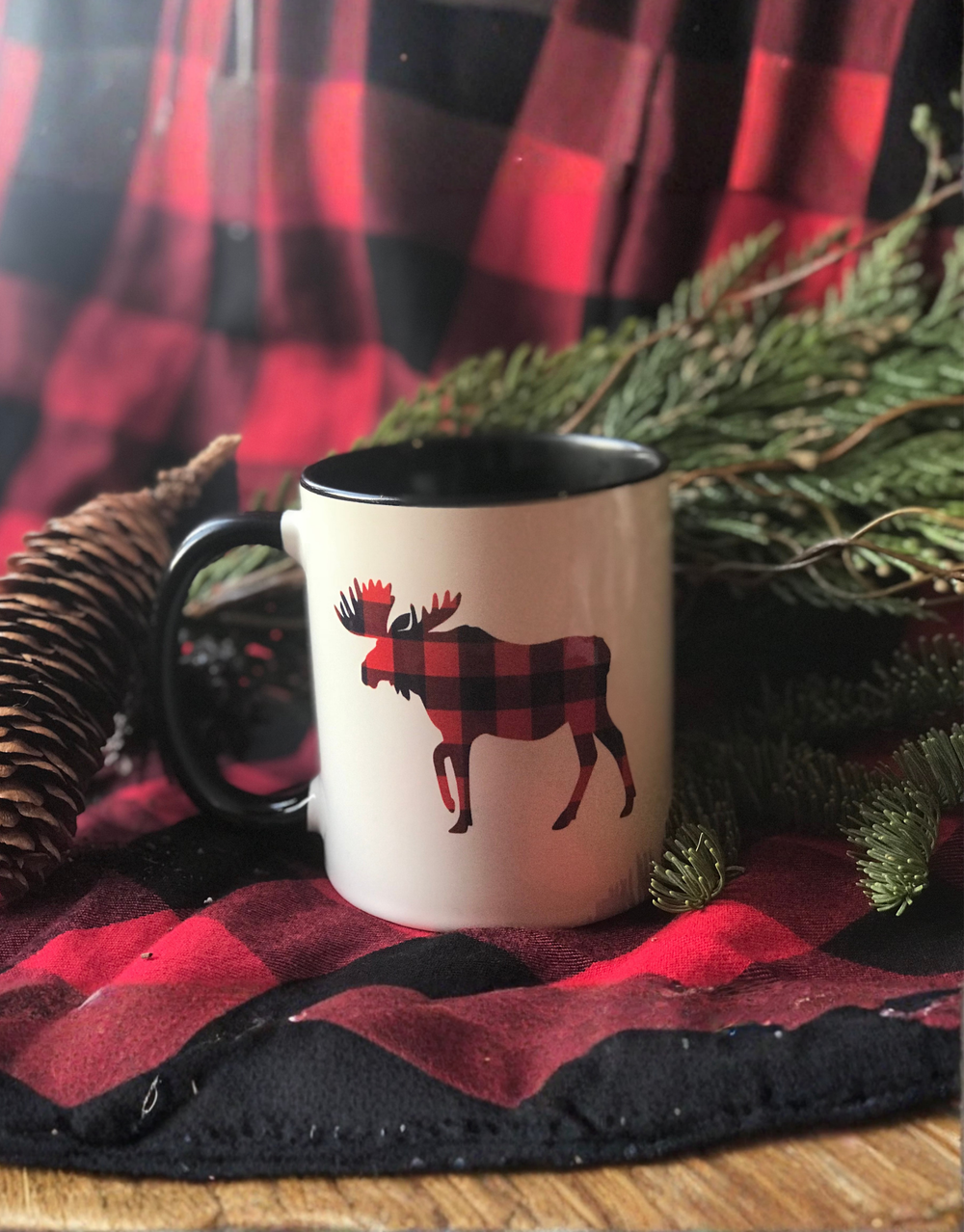 Mug with moose design on a red and black checkered fabric background