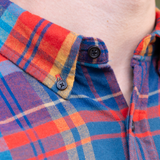 Close up of collar on mens orange blue and yellow plaid flannel shirt