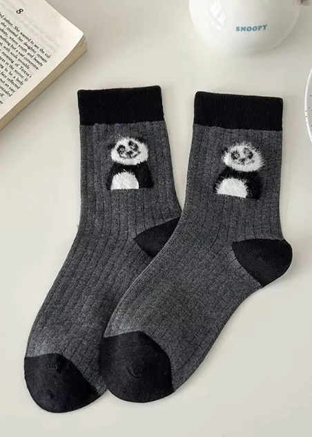 Gray cotton socks with panda design on a white surface