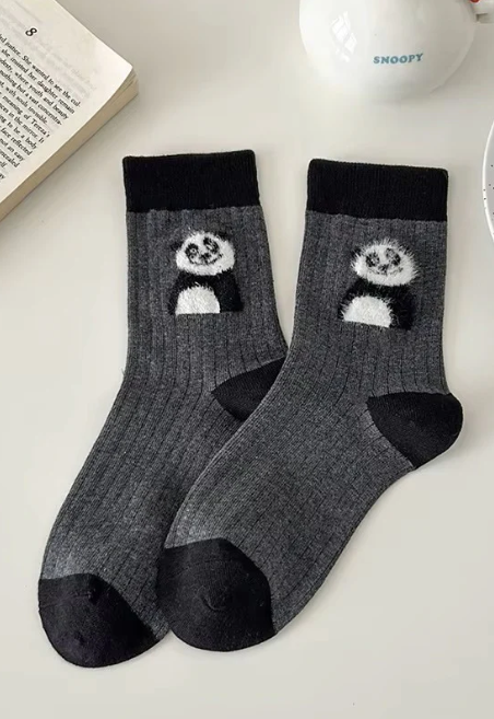 Gray cotton socks with panda design on a white surface