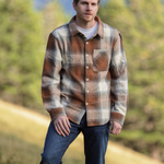 A person standing outdoors wearing a plaid flannel jacket with a herringbone weave in a blend of brown and grey tones, buttoned at the cuffs and chest.