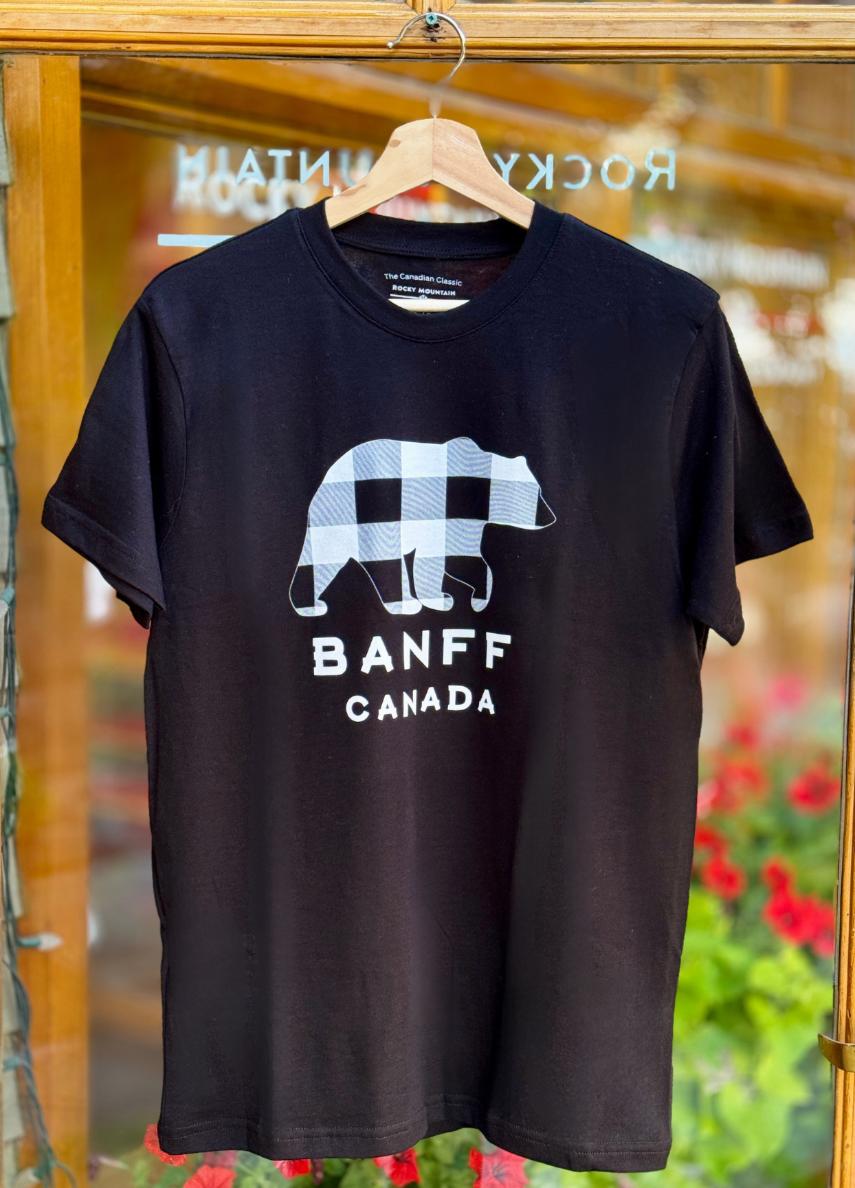 Black t-shirt with a bear graphic and 'Banff Canada' text on a hanger.
