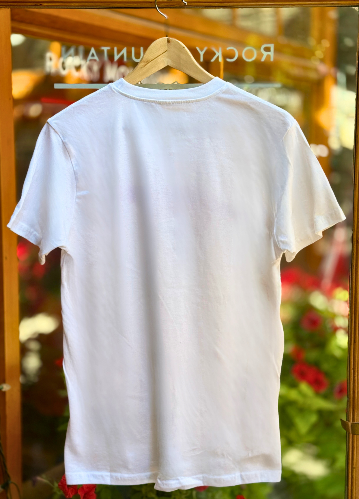 White t-shirt on a hanger with a blurred background