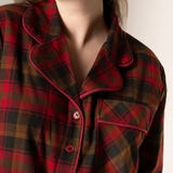 Close-up of a person wearing a maple leaf tartan nightshirt with a neutral background