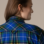 Person wearing a blue plaid nightgown against a neutral background