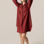 Woman wearing a red plaid dress against a beige background
