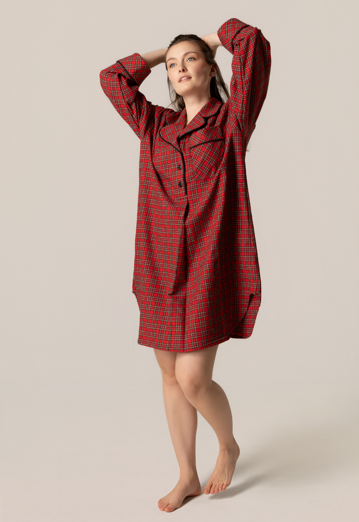 Woman wearing a red plaid dress against a beige background