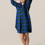 Woman wearing a nova scotia tartan nightshirt against a beige background