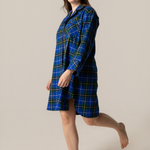 Woman wearing a blue plaid nightshirt on a beige background