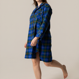 Woman wearing a blue plaid nightshirt on a beige background