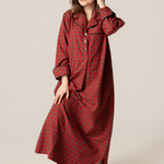 Woman wearing a red plaid nightgown against a plain background