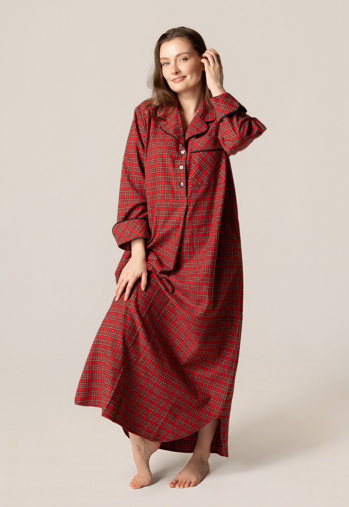 Woman wearing a red plaid nightgown against a plain background