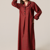 Woman wearing a red plaid nightgown against a beige background