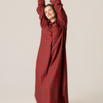Woman wearing a red checkered dress against a beige background