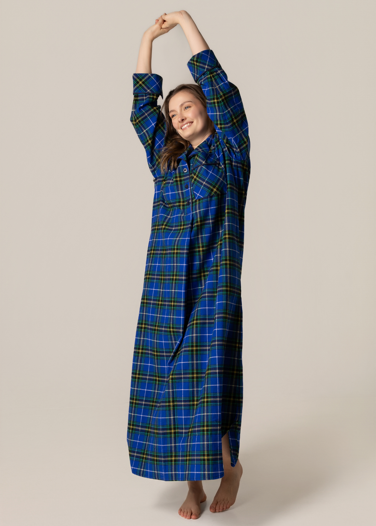 Person wearing a blue plaid nightgown against a beige background