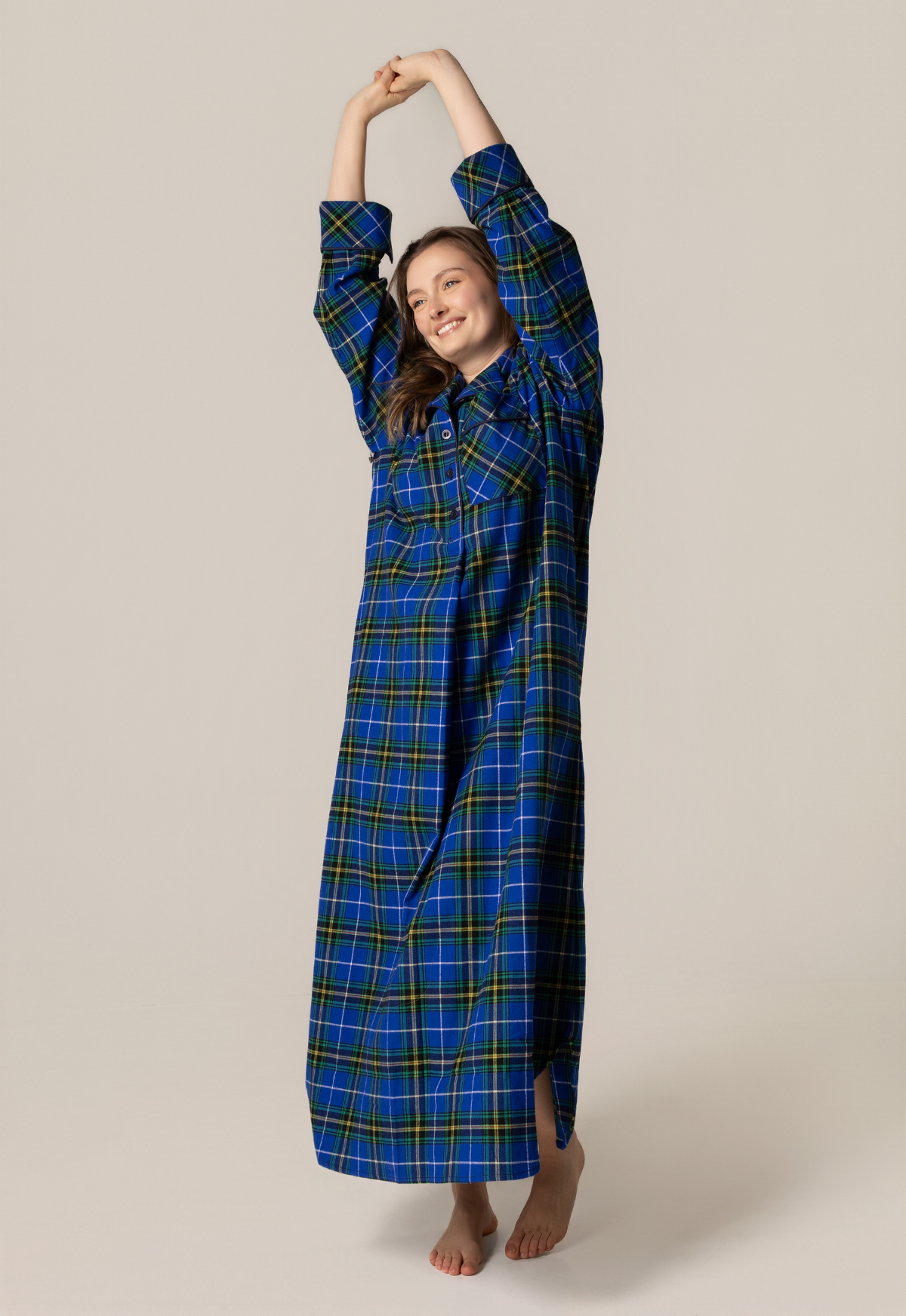 Person wearing a blue plaid nightgown against a beige background