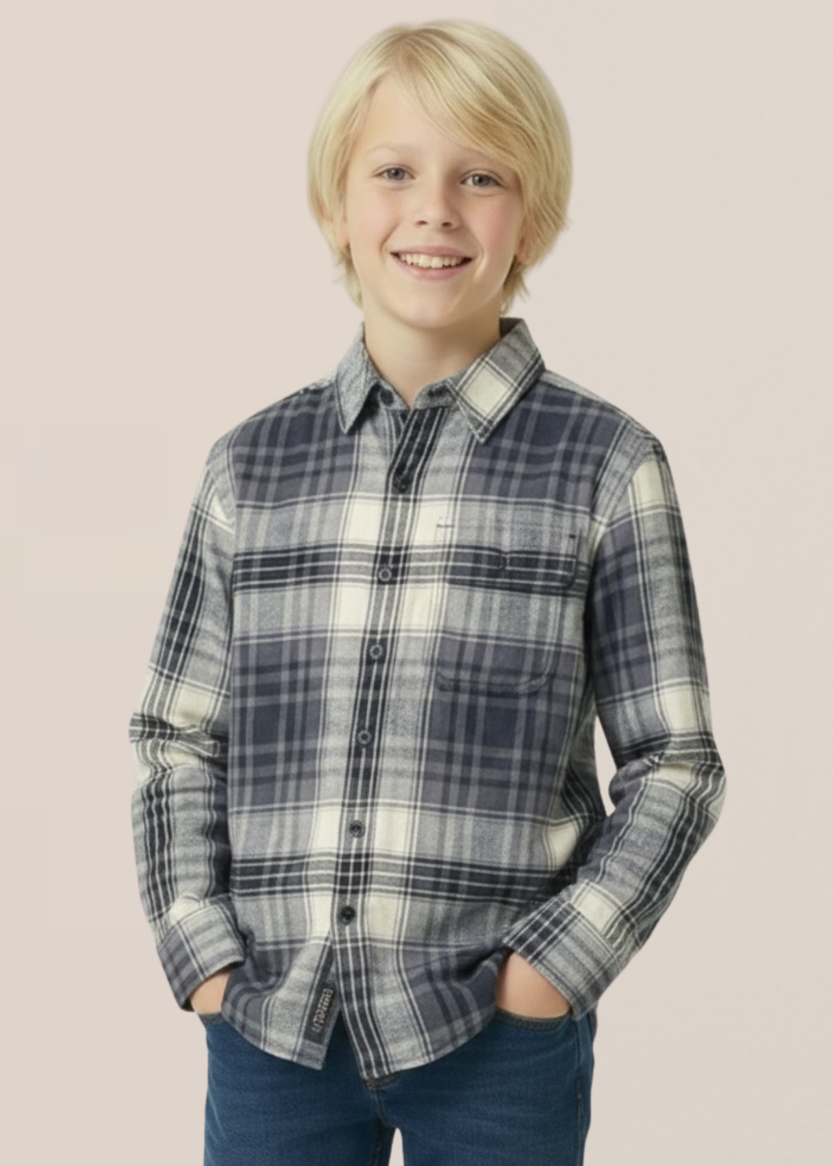 Young boy wearing a plaid shirt against a plain background