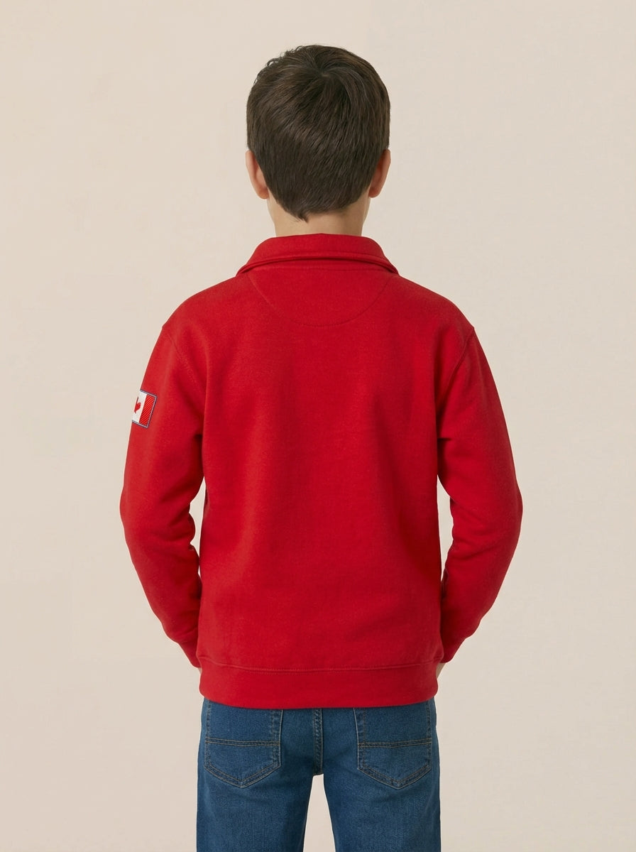 Person wearing a red jacket with a logo on the back against a beige background