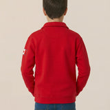 Person wearing a red jacket with a logo on the back against a beige background