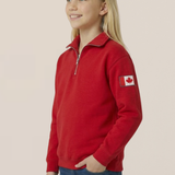 Child wearing a red polo with a Canadian flag patch on a beige background