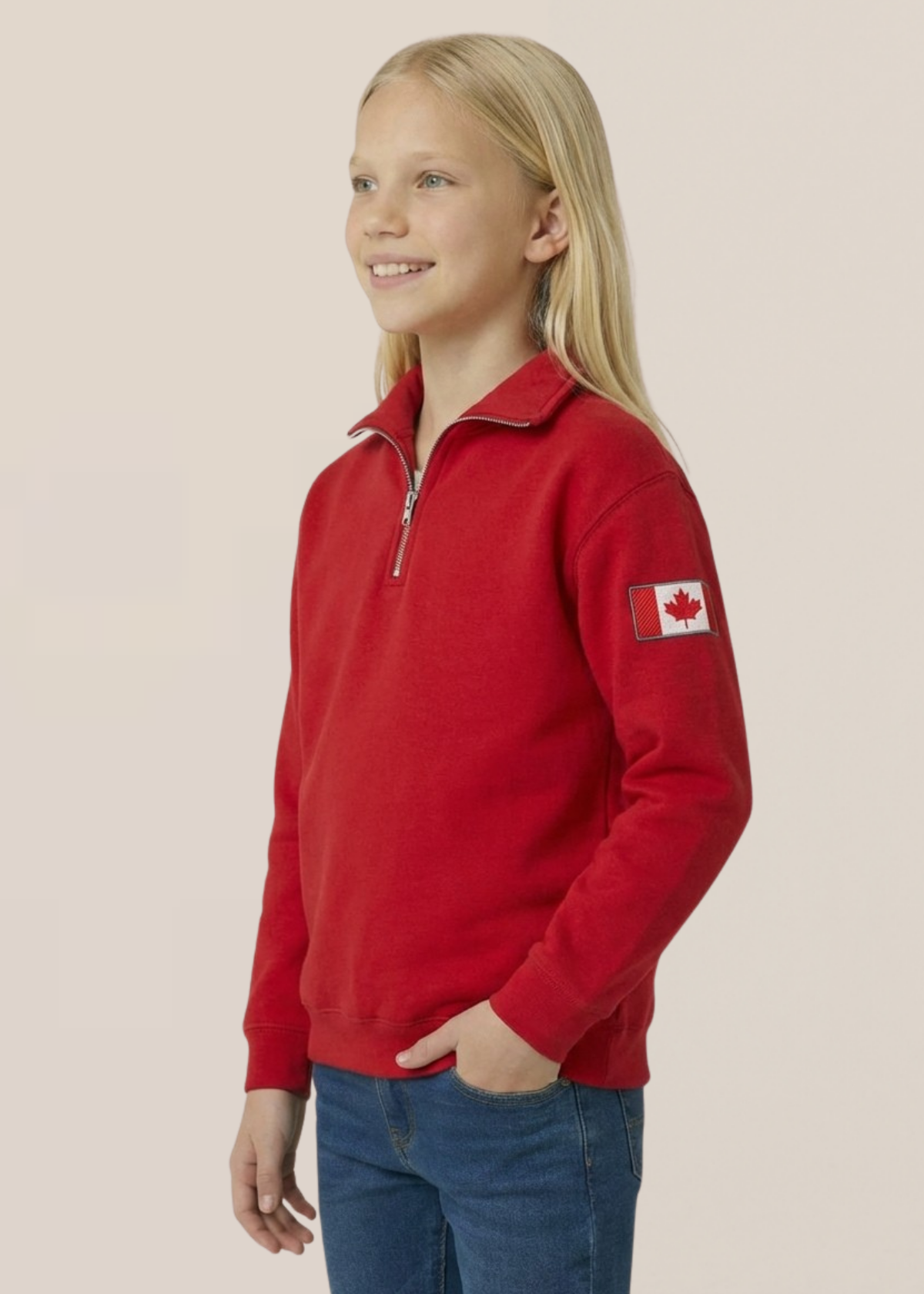 Child wearing a red polo with a Canadian flag patch on a beige background
