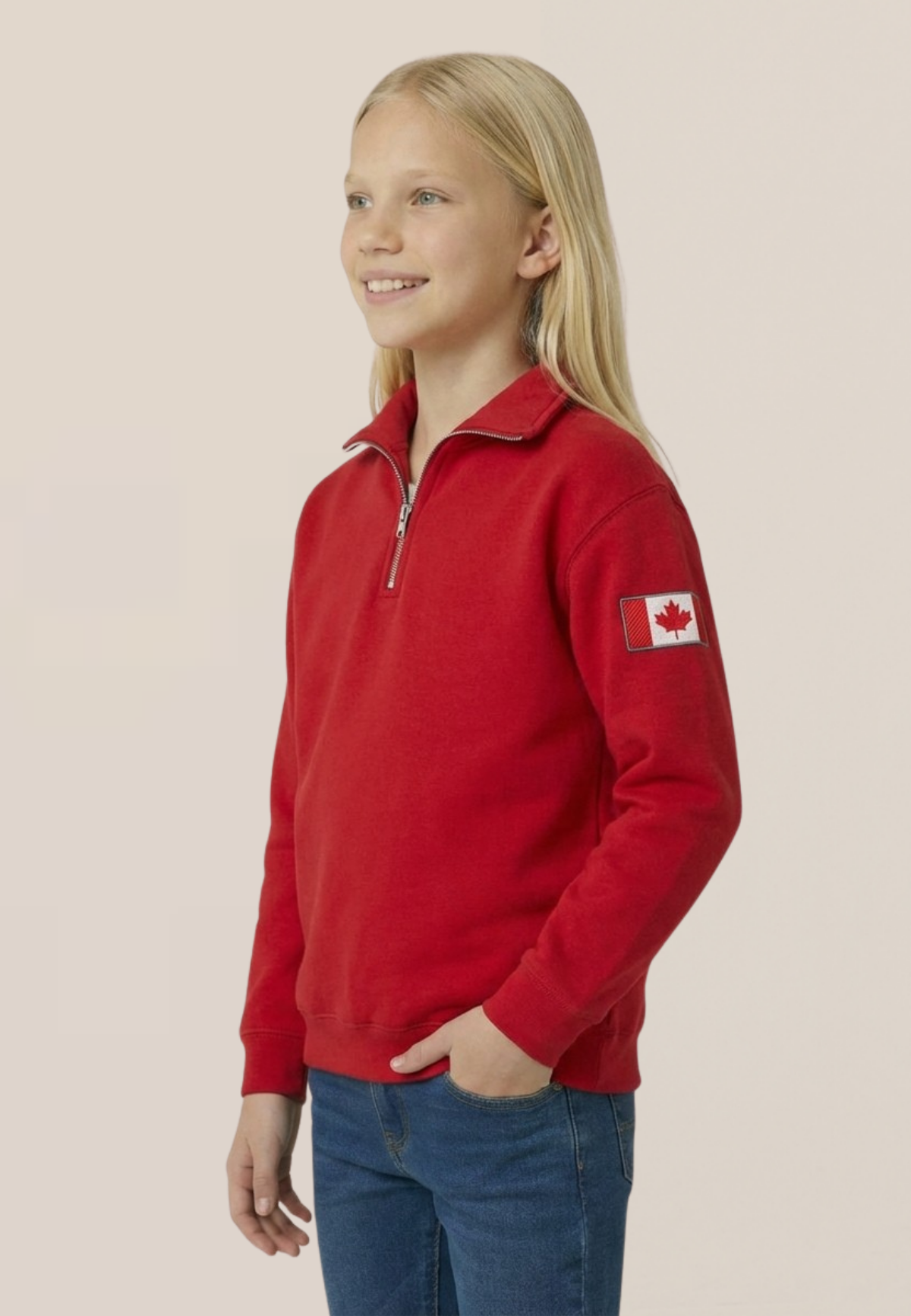 Child wearing a red polo with a Canadian flag patch on a beige background